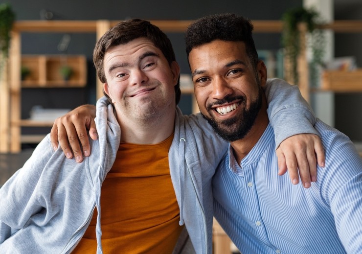 Two men smiling  one of them with Down Syndrome