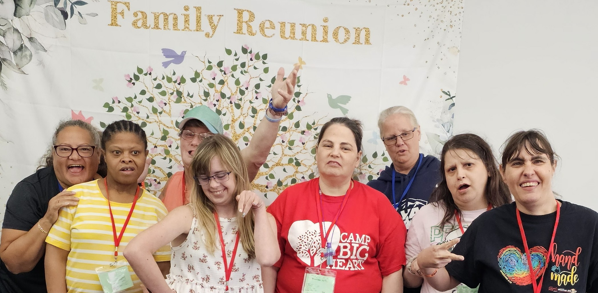 Group of women posing in front of Family Reunion sign