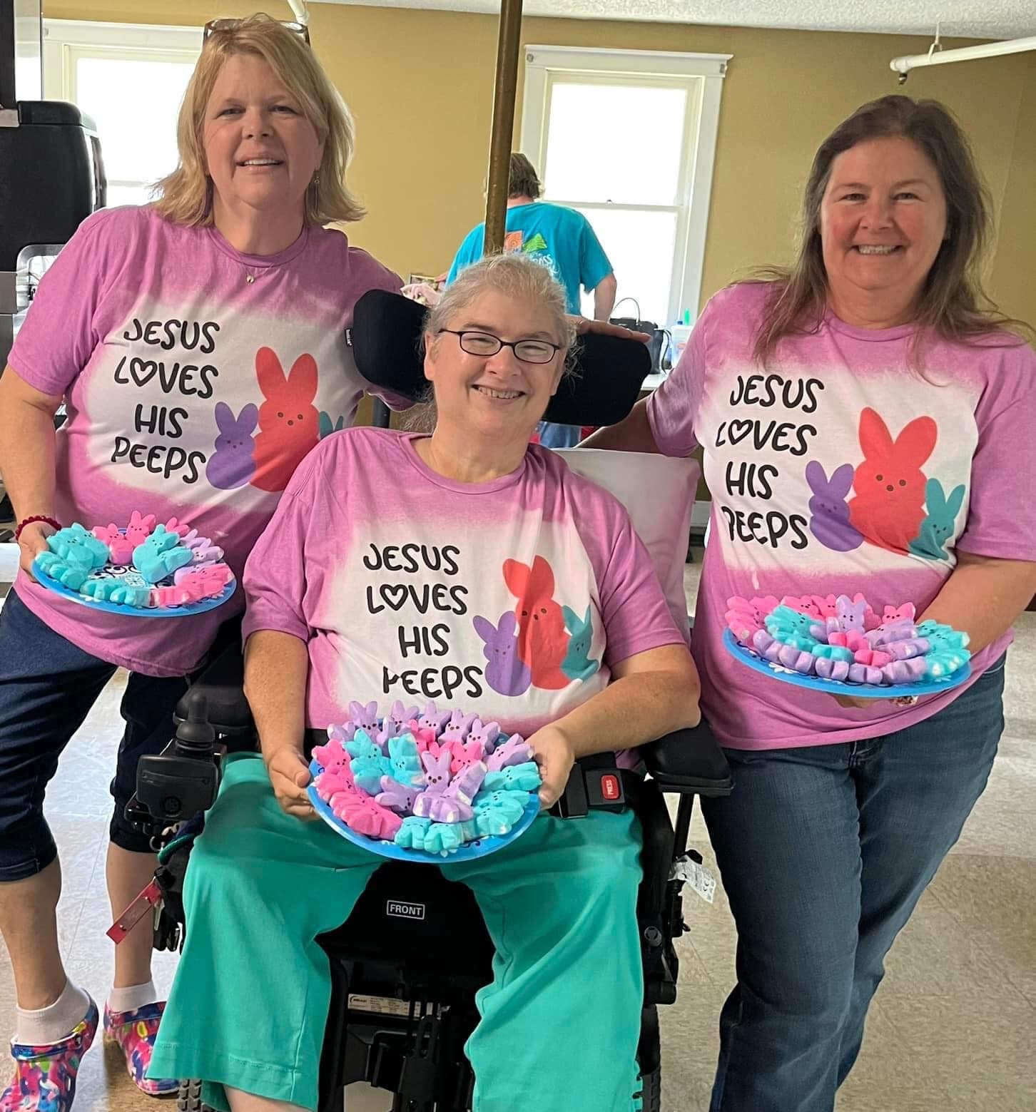 Three people from Florida Chapters wearing shirts saying Jesus loves his Peeps and holding marshmellow bunnies