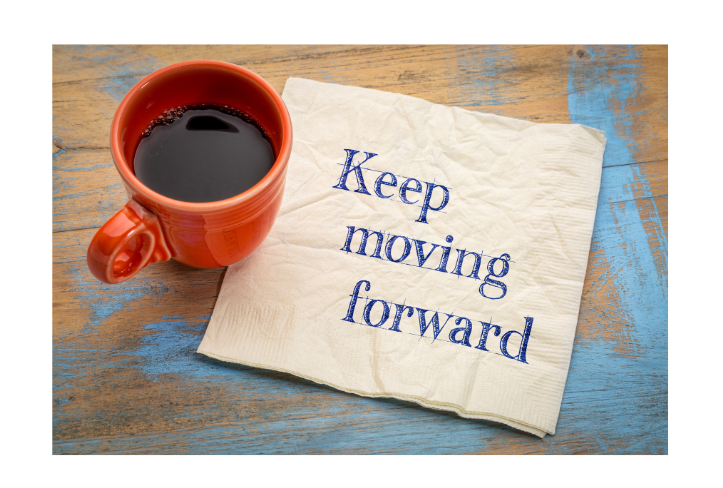 Cup filled with coffee and napkin that reads Keep moving forward