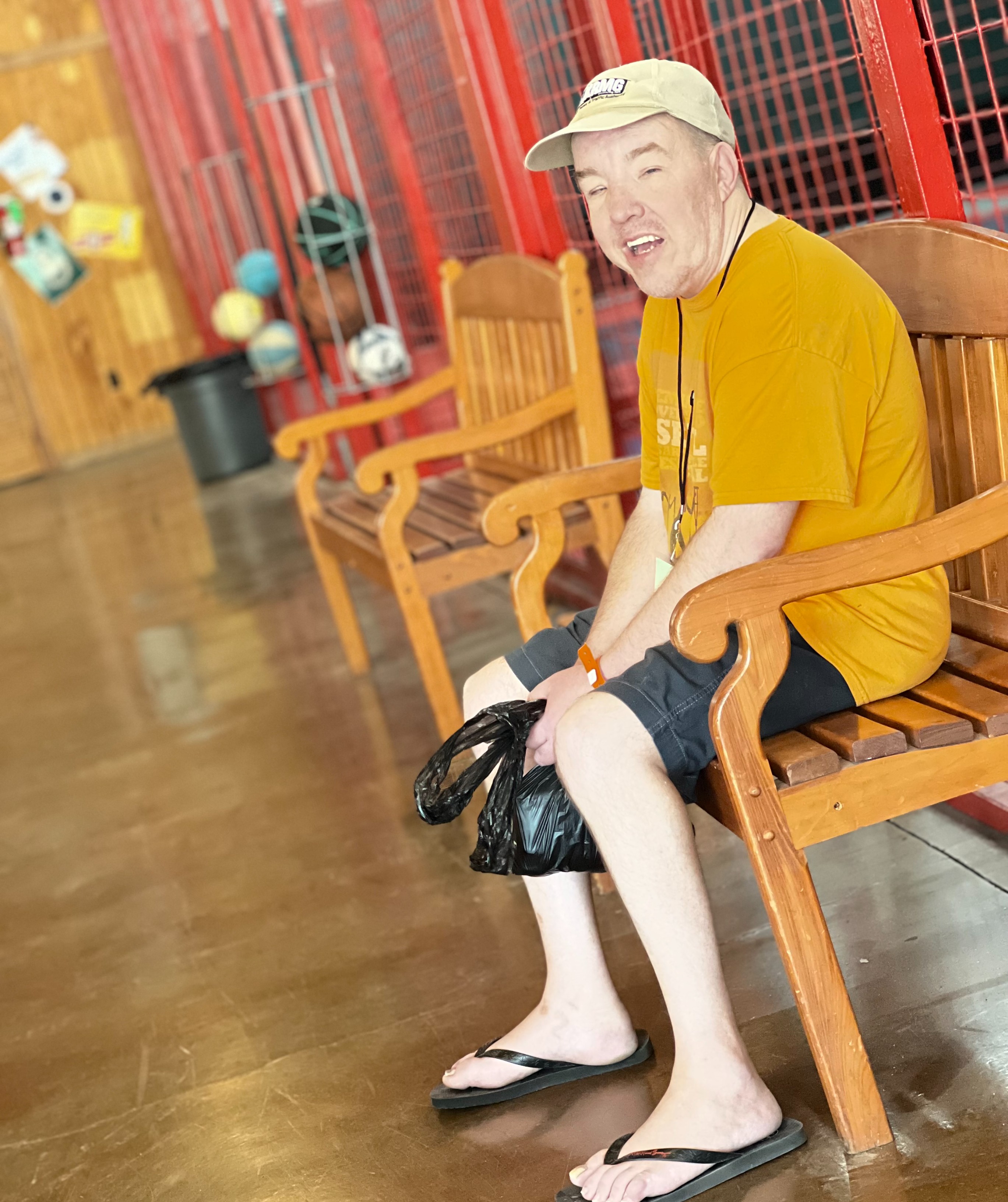 one man wearing sandals smiling as he sits waiting