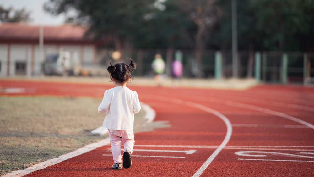 Little girl walking on a race track