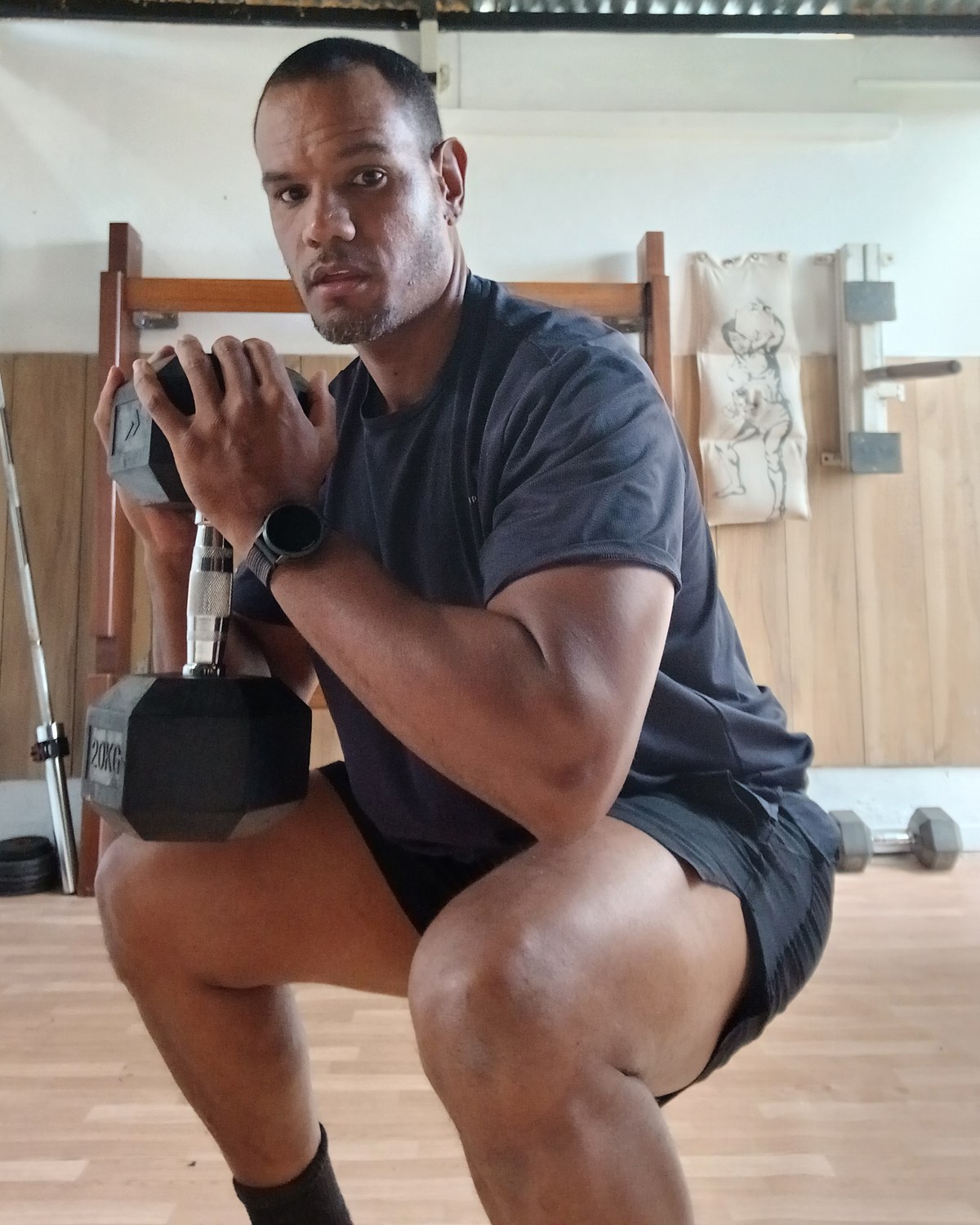 Yohann en squat avec un haltère, à domicile