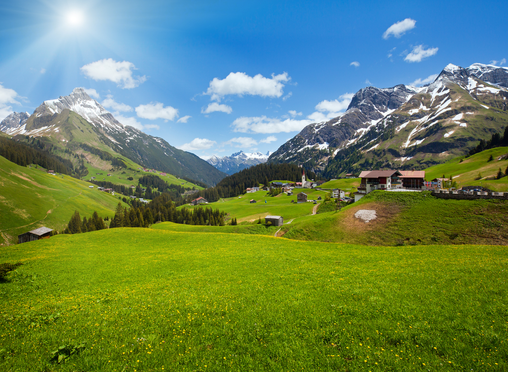 Alpine fields with mountains and blue sky 