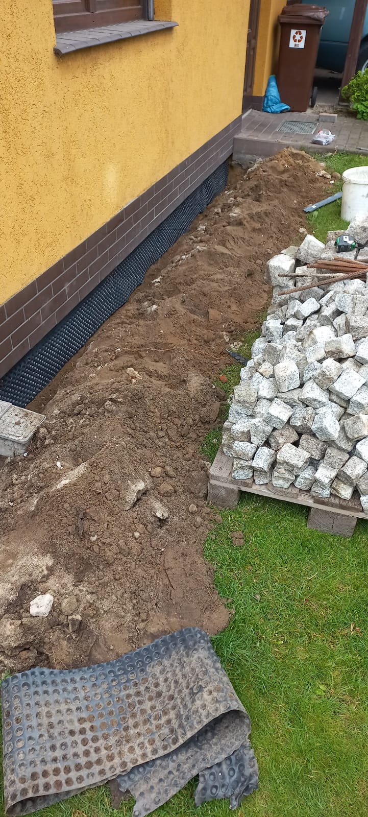 Poprawienie izolacji fundamentów, układanie kostki granitowej