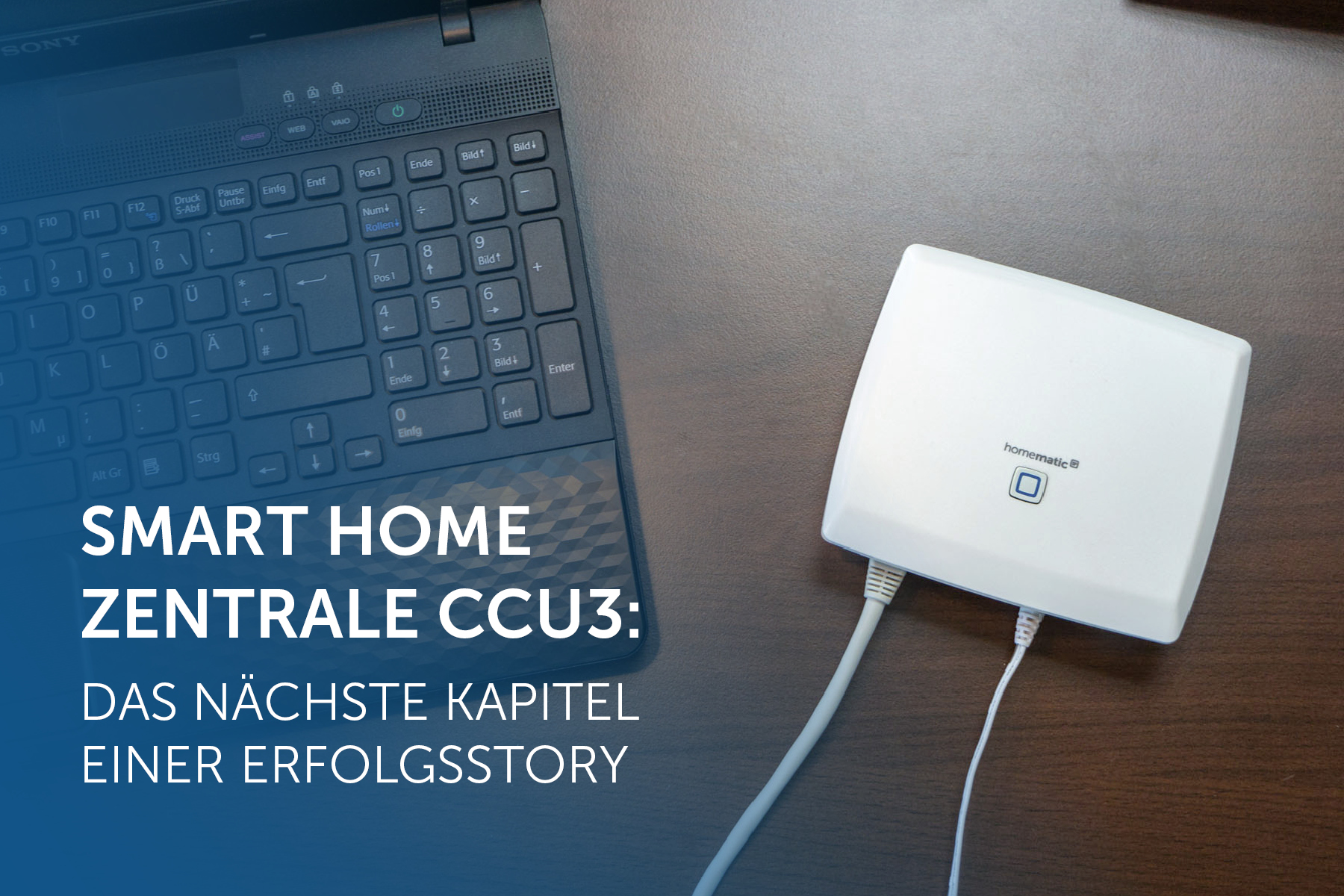 CCU3 auf einem dunklen Holztisch liegend, links daneben ein Laptop.