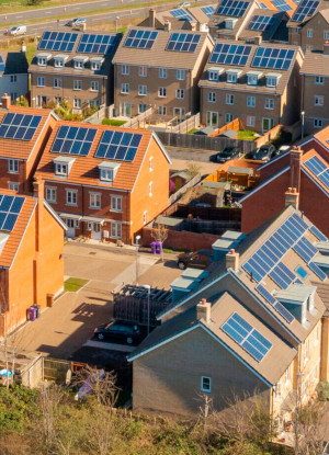 A photo of a new-build housing estate with solar panels on every rooftop.