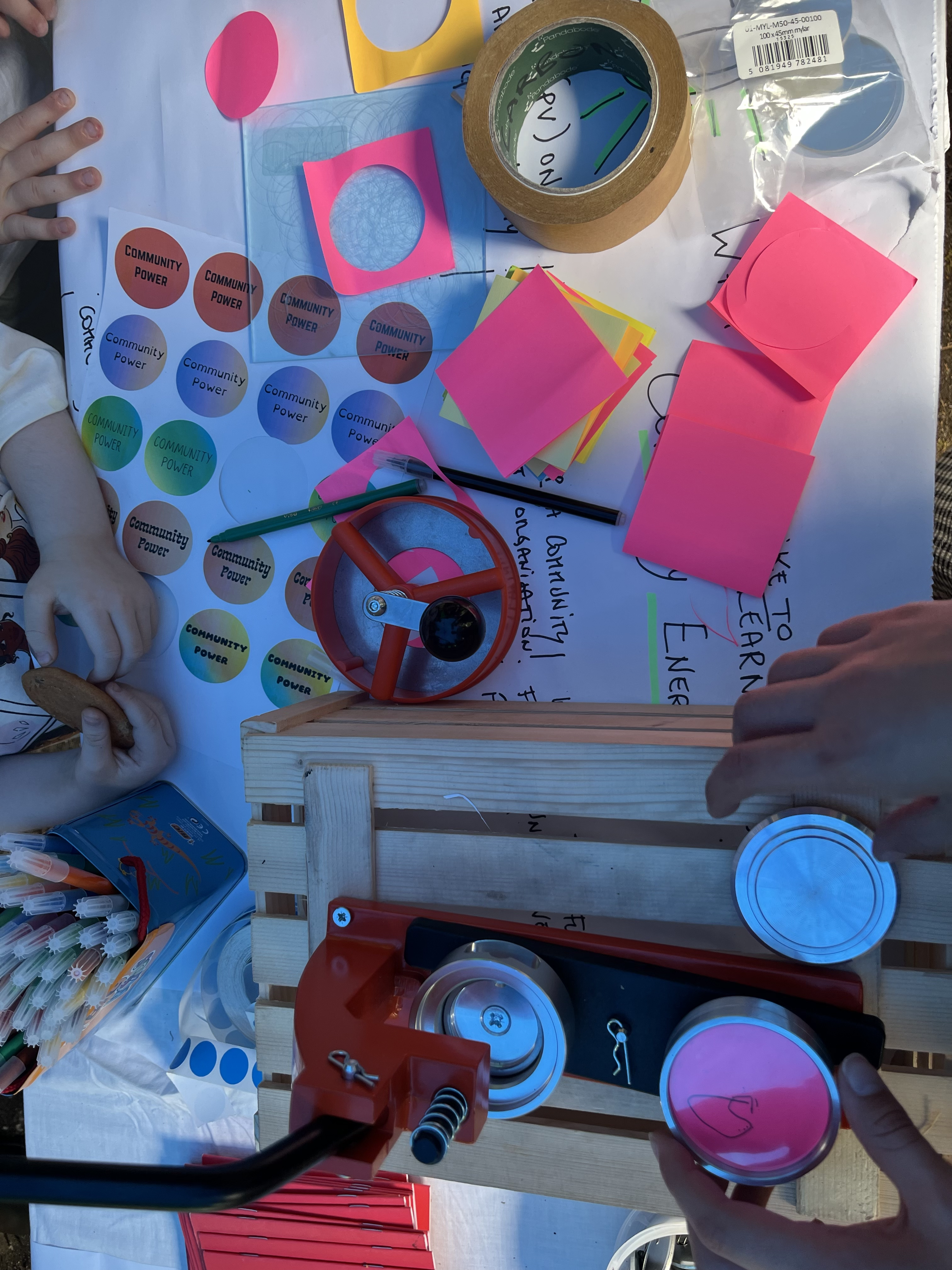 A top down photo of people making community energy themed badges at the Greenstock Carbon Co-op stall