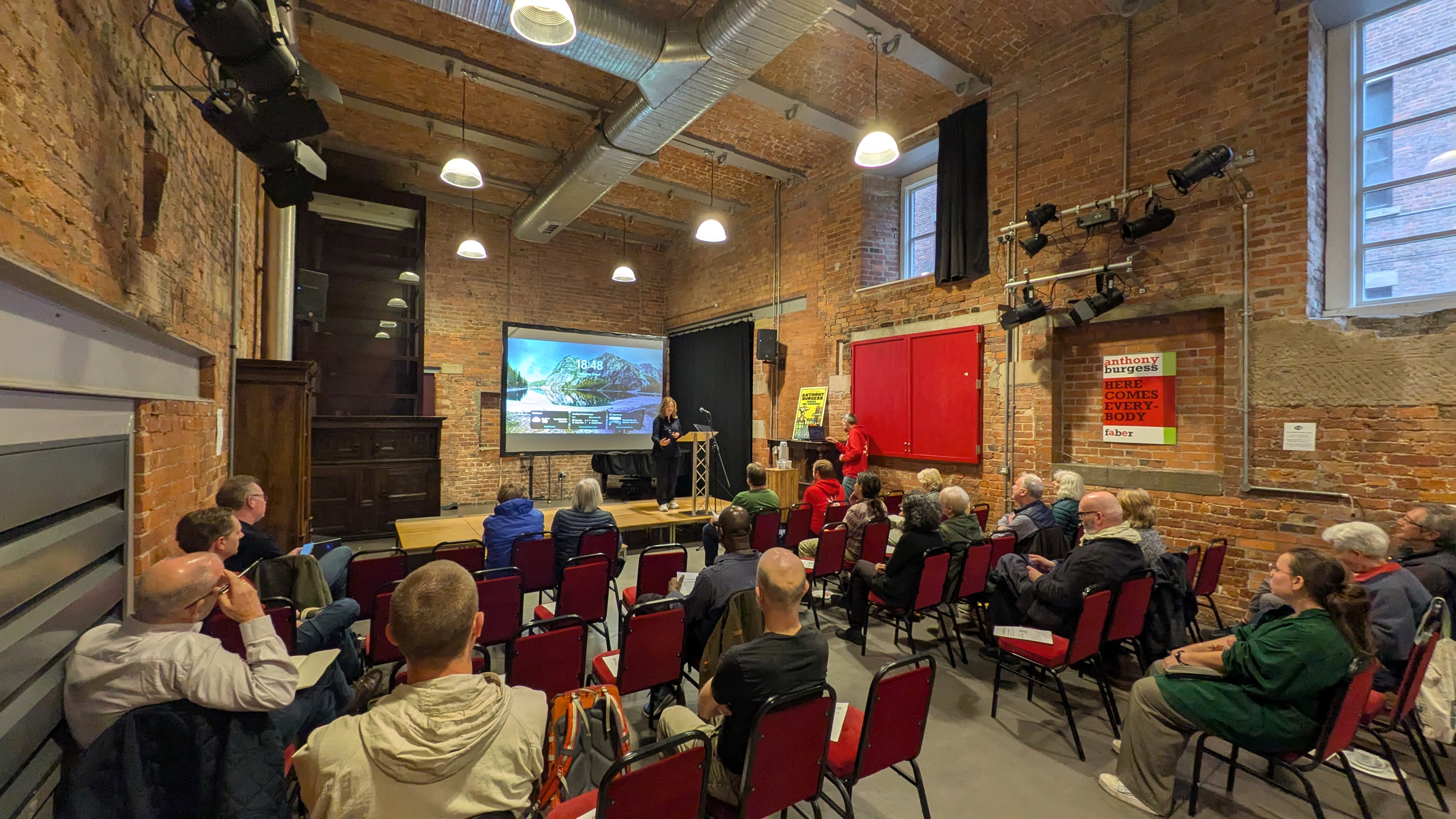 A photo of a room of people sitting in rows watching a presentation at the Carbon Co-op 2025 AGM