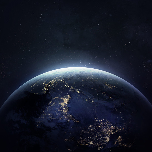A photo from space of the world at night at the cusp of dawn