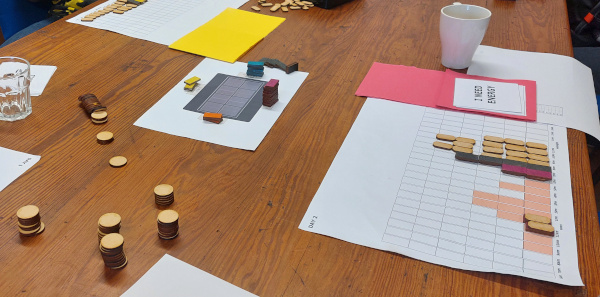 A photo of the table during our shared battery workshop where counters and game elements are visible