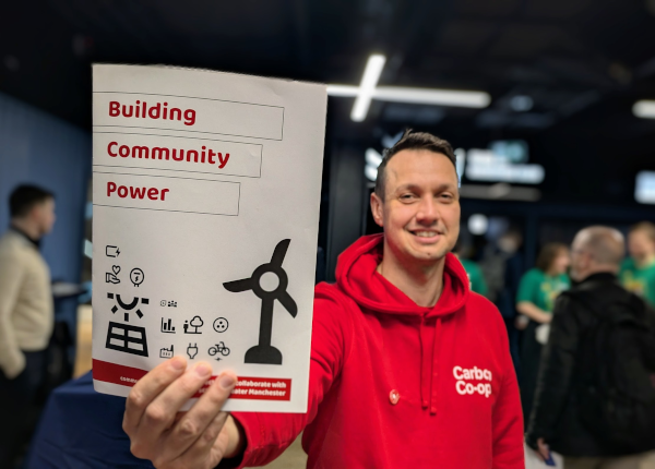 A photo of a group of people at a networking event, sitting at a table with a lot of biscuits and snacks