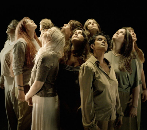 A photo of performers from the Songs of the Storm to Come exhibition with women looking upwards