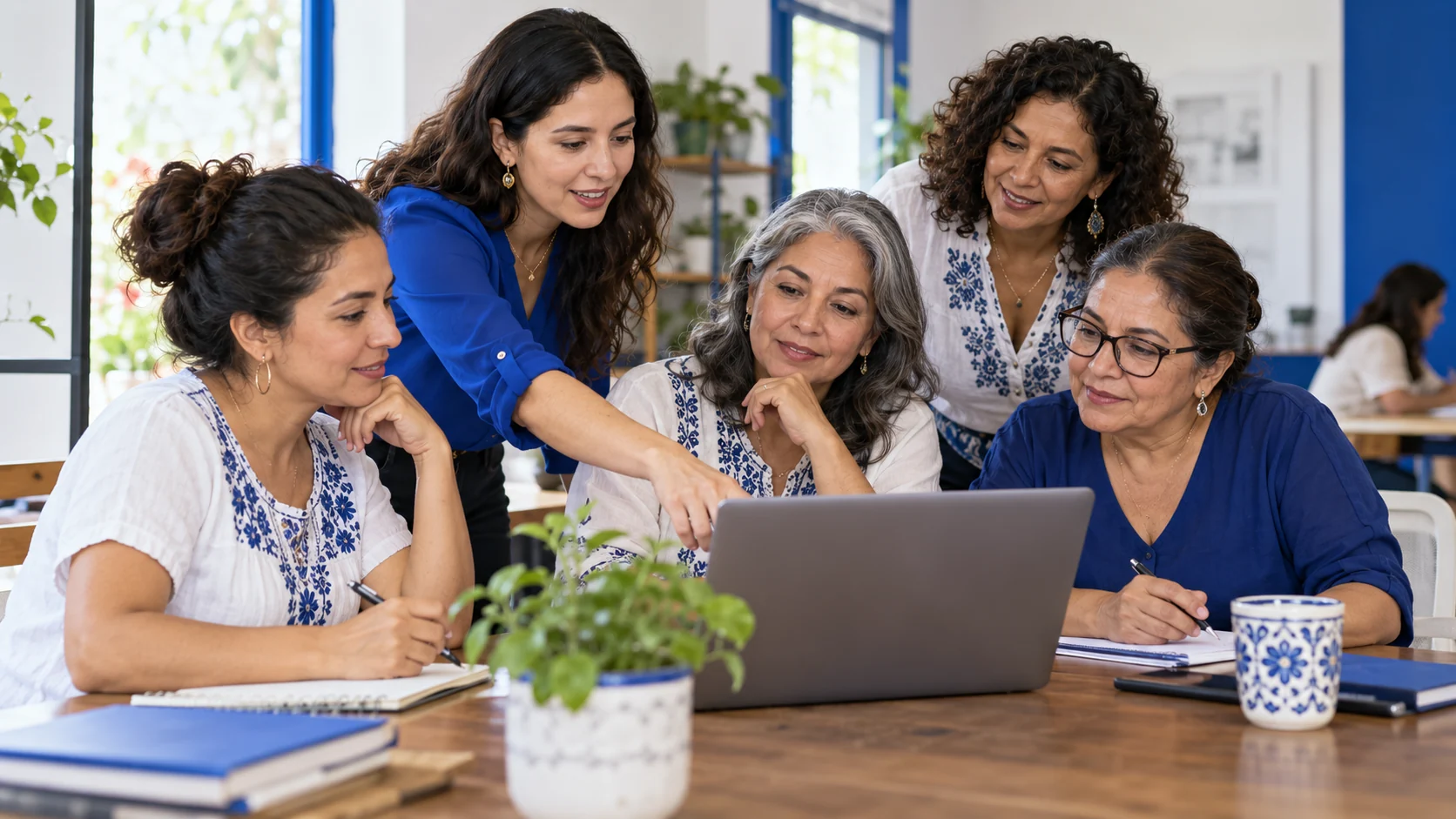 Mujeres emprendedoras aprendiendo juntas frente a una computadora.