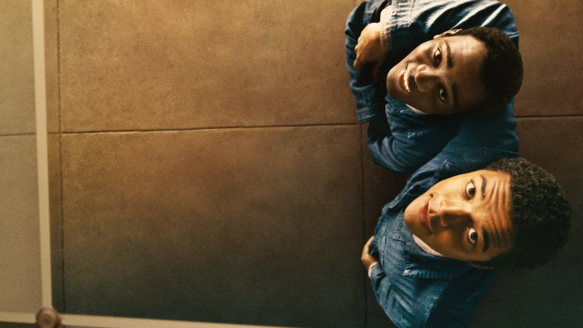 two smiling men of colour looking up at the camera