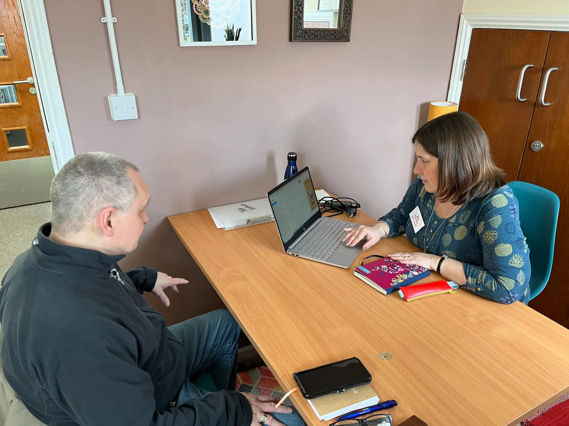 A Stay Nimble career coach working with someone at a table in Corbett Community Library
