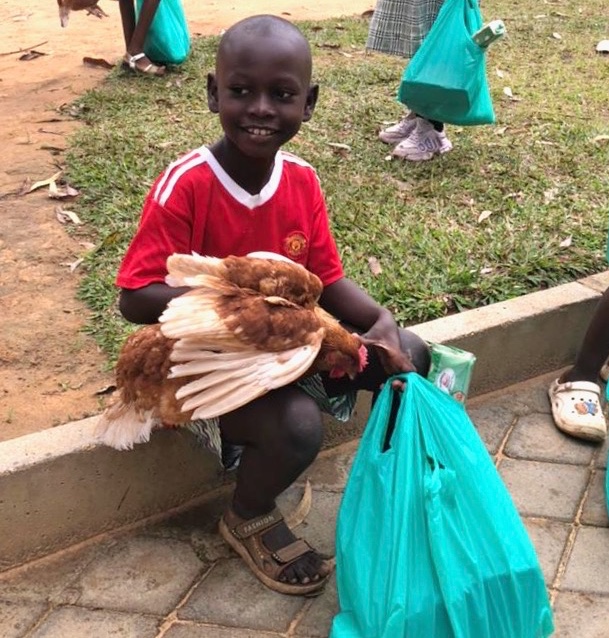 Mustard Seed children with food bag, soap, and chicken 