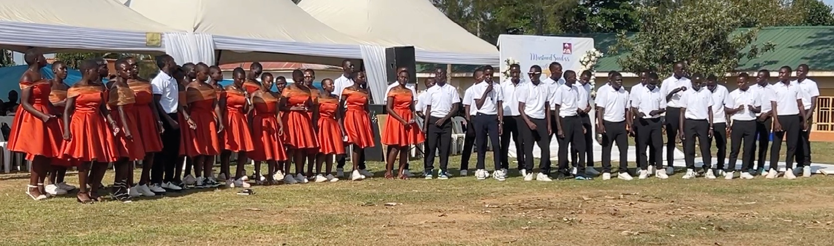 Forty young-adult Ugandan students dressed in party clothes, lined up and singing.