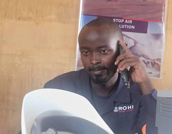 Three young Ugandan men with an older man with beautiful trees and shrubs in the background