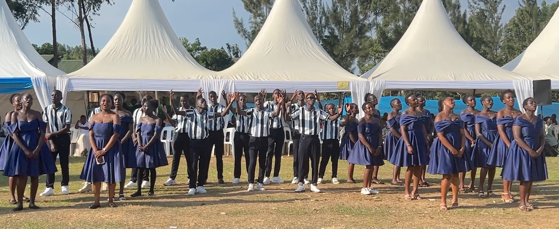 Teen-aged girls in fancy blue dresses and boys in black pants and stripted shirts.