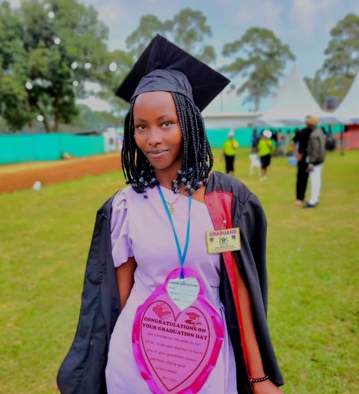 A young Ugandan woman in a graduation robe and cap