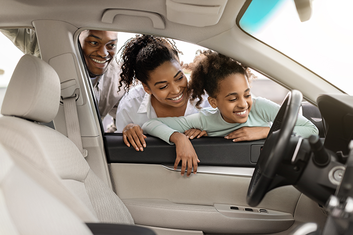 Family looking at a car in dealership